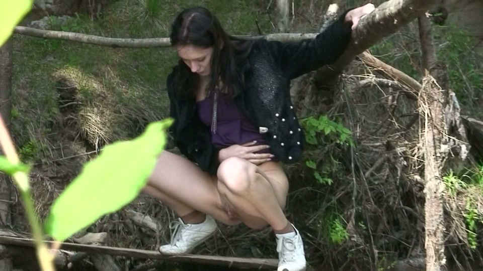 Studentessa russa magra e bruna piscia nella foresta